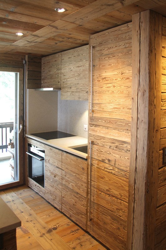 Détail d’une cuisine avec armoires et façades en vieux bois