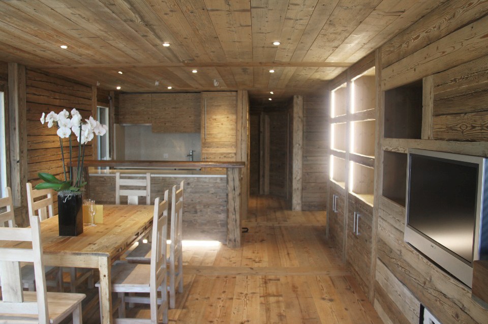 Pièce de vie agencée en vieux bois, avec cuisine et espace repas