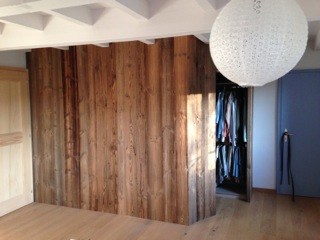 Paroi et portes en vieux bois dans un intérieur contemporain